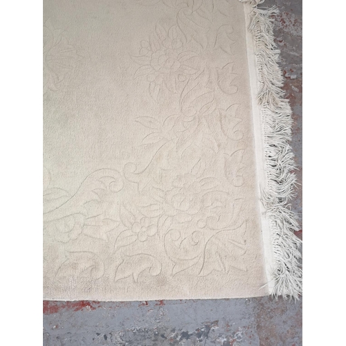 264 - A beige floral patterned rug - approx. 200cm x 135cm