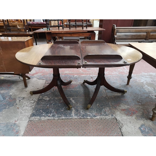 293 - An early 20th century mahogany oval extending dining table with brass castors