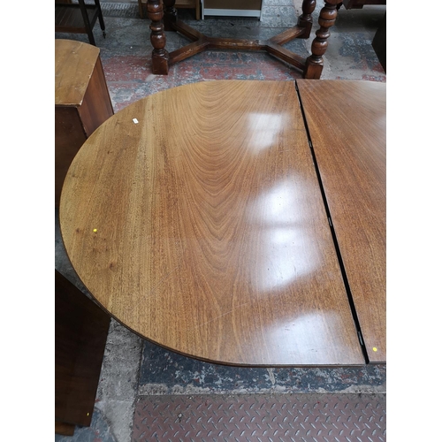 293 - An early 20th century mahogany oval extending dining table with brass castors