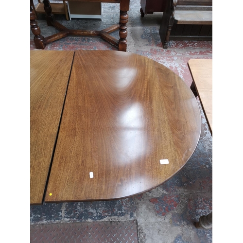 293 - An early 20th century mahogany oval extending dining table with brass castors