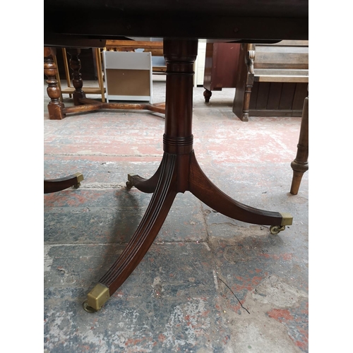 293 - An early 20th century mahogany oval extending dining table with brass castors