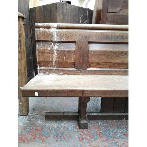 311 - A late 19th/early 20th century solid oak church pew - approx. 91cm high x 145cm wide x 50cm deep