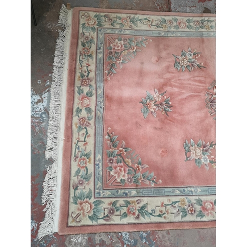 323 - A pink and cream floral patterned rug - approx. 285cm x 180cm