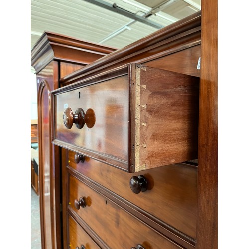 298 - A Victorian mahogany triple wardrobe with two outer panelled doors, two short drawers and five long ... 