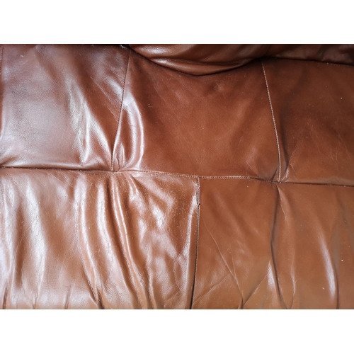 365 - A brown leather and carved oak three piece lounge suite comprising two two seater sofas and one thre... 