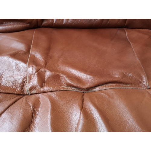 365 - A brown leather and carved oak three piece lounge suite comprising two two seater sofas and one thre... 