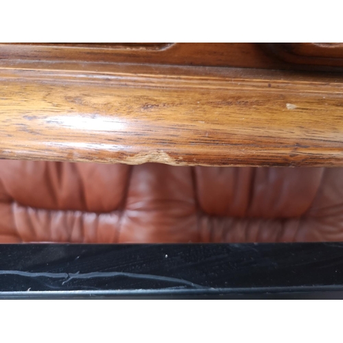 365 - A brown leather and carved oak three piece lounge suite comprising two two seater sofas and one thre... 