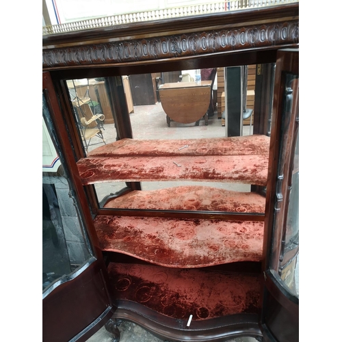 379 - An early 20th century mahogany two door glazed display cabinet with hand painted panelled doors, bra... 