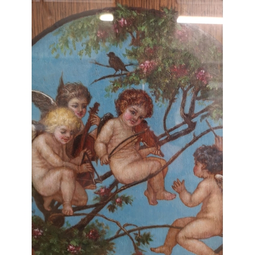 410 - An early 20th century gilt framed oil painting on oak panel of a cherub band signed lower left - app... 