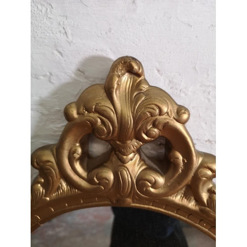 414 - A 19th century style gilt framed oval wall mirror with cherub design - approx. 70cm high x 45cm wide