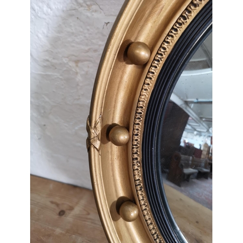 417 - A Regency style gilt framed convex wall mirror with eagle design - approx. 70cm high x 47cm wide