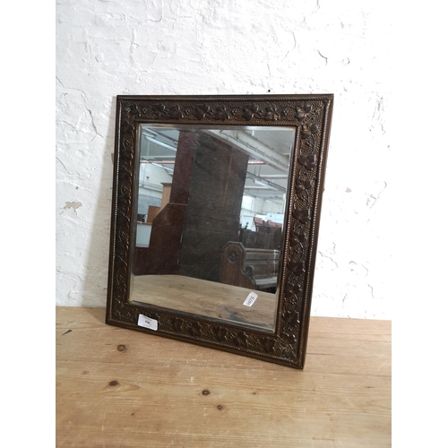 418 - A vintage brass framed bevelled edge wall mirror with foliate design - approx. 41cm high x 36cm wide