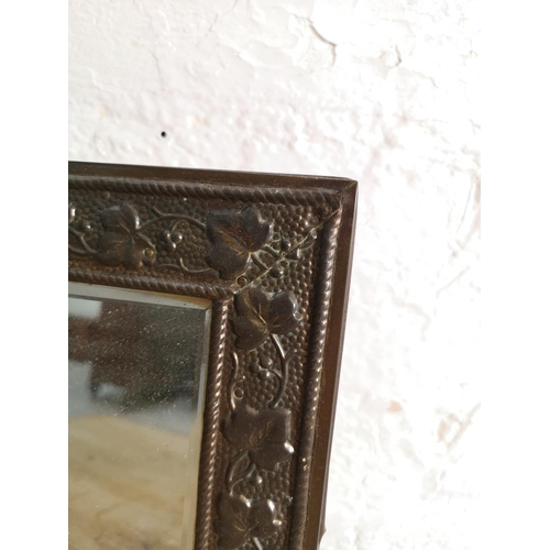 418 - A vintage brass framed bevelled edge wall mirror with foliate design - approx. 41cm high x 36cm wide