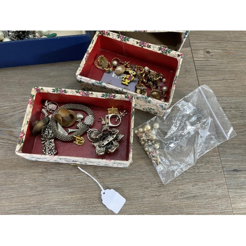 116 - Two boxes containing costume jewellery to include earrings, brooches etc.