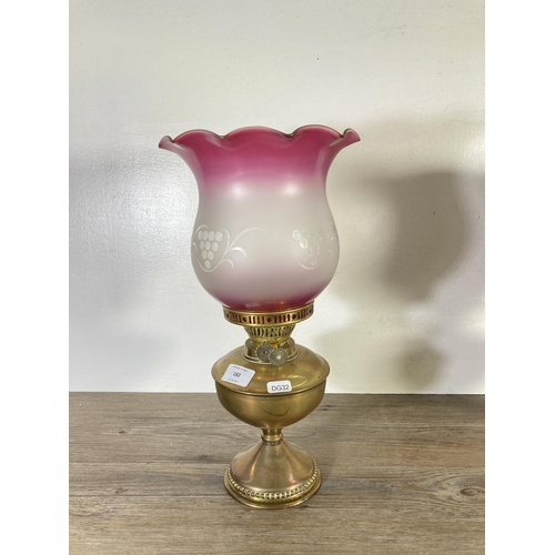 182 - Two early 20th century brass oil lamps with glass shades