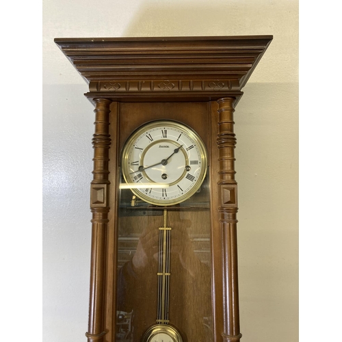 201 - A Hermle mahogany cased wall clock with pendulum and key