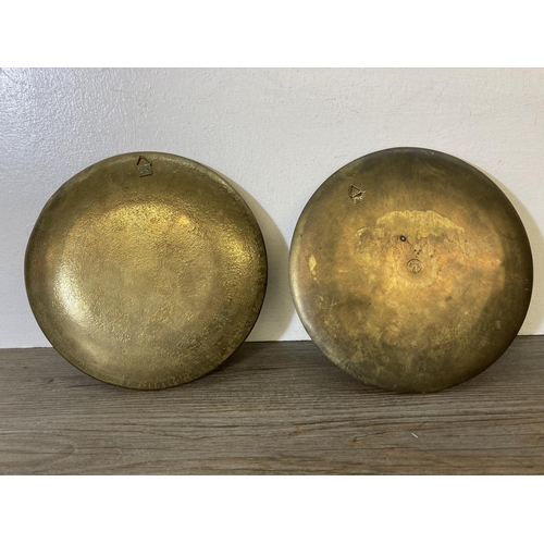 226 - Two enamel circular wall chargers, one stamped 'bronze' to reverse - approx. 20cm diameter