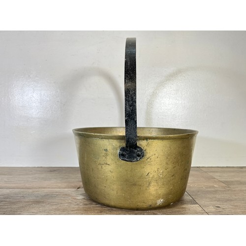 60 - Eight pieces of metalware to include brass chamberstick, Victorian brass preserve pan, four blow tor... 