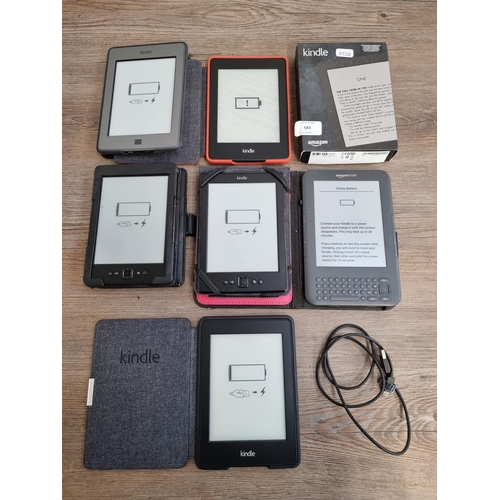 584 - Seven Amazon Kindle E-readers, six cased and one boxed