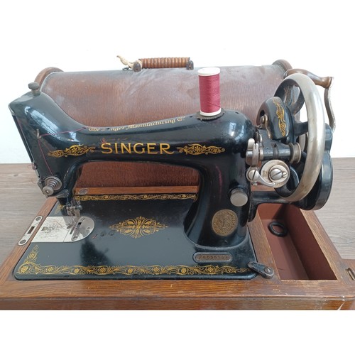 1546 - A cased c.1917 Singer No. 99 hand crank sewing machine with attachments and instruction manual - ser... 