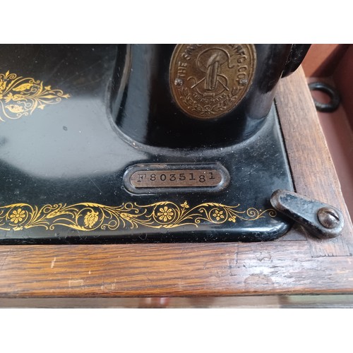 1546 - A cased c.1917 Singer No. 99 hand crank sewing machine with attachments and instruction manual - ser... 