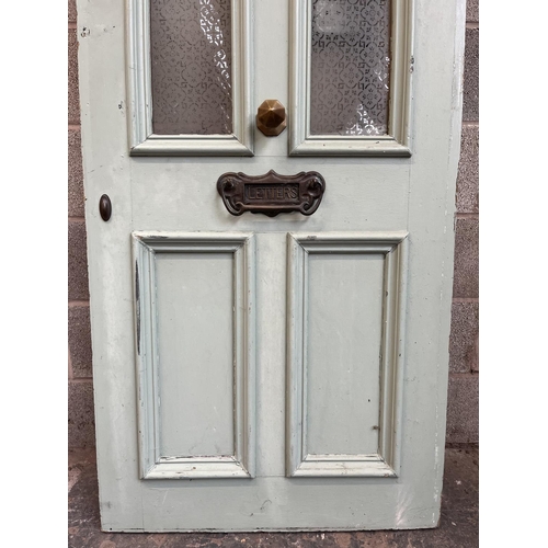 1007 - A green painted pine door with brass letterbox and handle - approx. 201cm high x 81cm wide