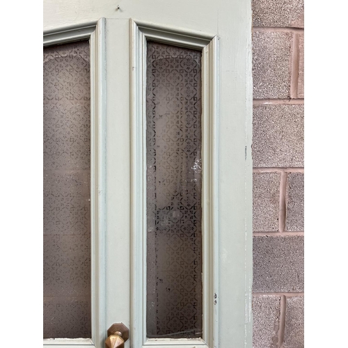 1007 - A green painted pine door with brass letterbox and handle - approx. 201cm high x 81cm wide