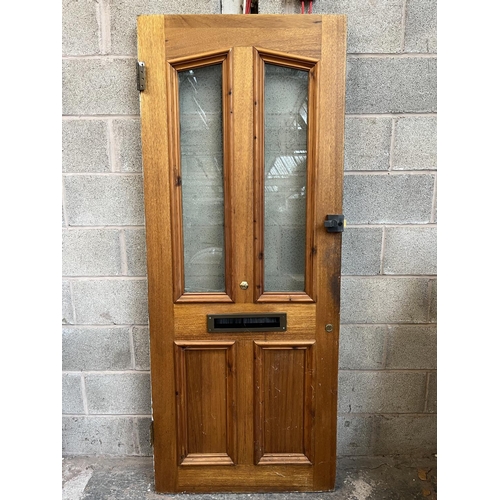 1007 - A green painted pine door with brass letterbox and handle - approx. 201cm high x 81cm wide