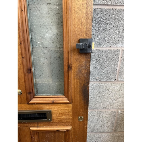 1007 - A green painted pine door with brass letterbox and handle - approx. 201cm high x 81cm wide