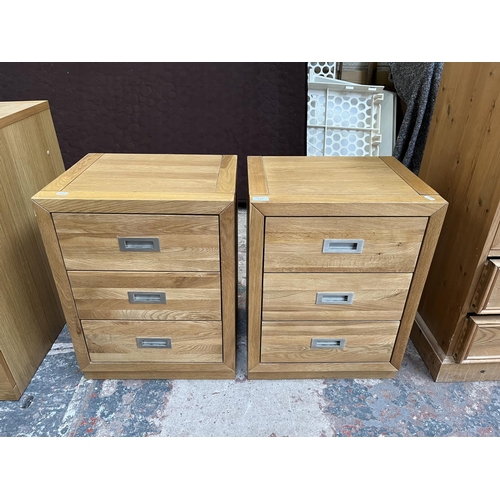 1014 - A pair of modern oak bedside chests of three drawers - approx. 62cm high x 47cm wide x 38cm deep