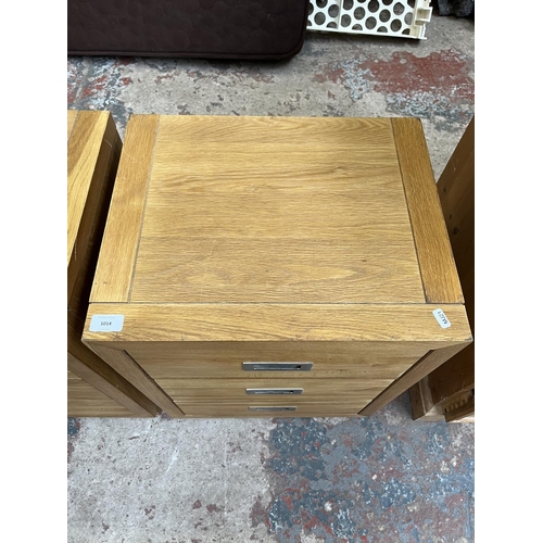 1014 - A pair of modern oak bedside chests of three drawers - approx. 62cm high x 47cm wide x 38cm deep