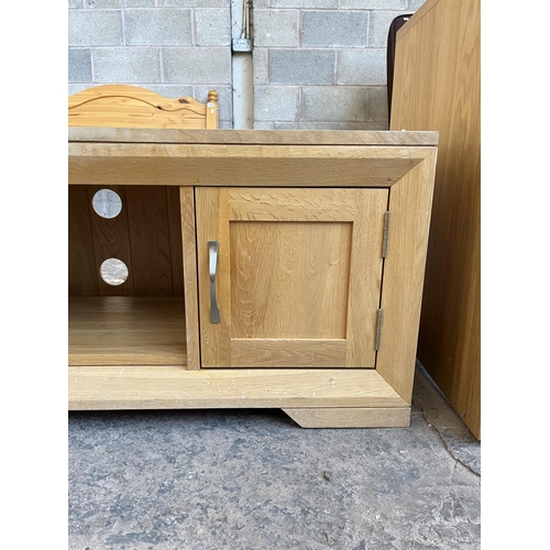 1016 - A modern oak TV stand with two cupboard doors - approx. 48cm high x 124cm wide x 45cm deep