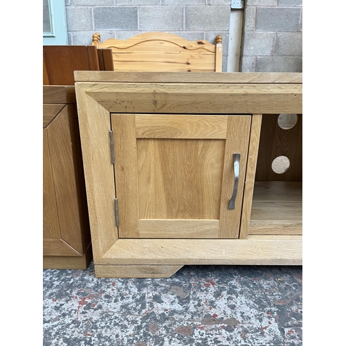 1016 - A modern oak TV stand with two cupboard doors - approx. 48cm high x 124cm wide x 45cm deep