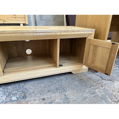 1016 - A modern oak TV stand with two cupboard doors - approx. 48cm high x 124cm wide x 45cm deep