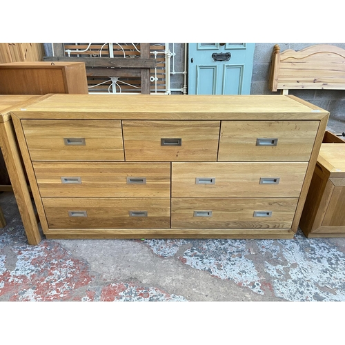 1018 - A modern oak chest of three short and four long drawers - approx. 76cm high x 145cm wide x 42cm deep