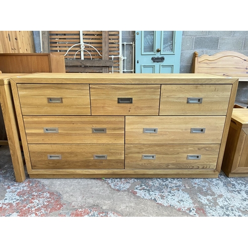 1018 - A modern oak chest of three short and four long drawers - approx. 76cm high x 145cm wide x 42cm deep