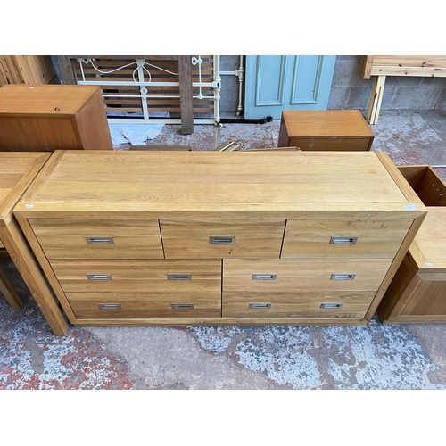 1018 - A modern oak chest of three short and four long drawers - approx. 76cm high x 145cm wide x 42cm deep