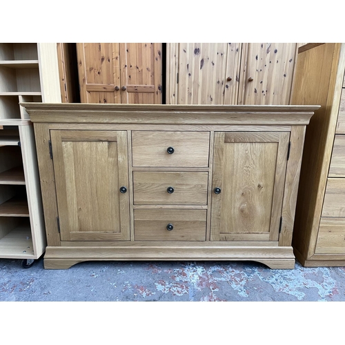 1021 - A modern solid oak sideboard with three central drawers and two outer cupboard doors - approx. 85cm ... 