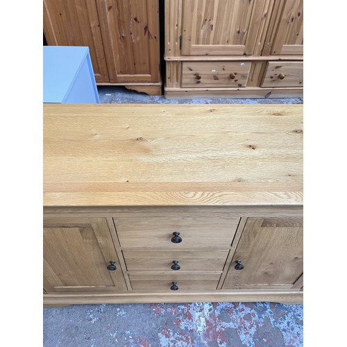 1021 - A modern solid oak sideboard with three central drawers and two outer cupboard doors - approx. 85cm ... 