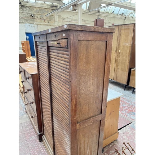 1031 - An early 20th century oak double tambour door cabinet - approx. 152cm high x 87cm wide x 37cm deep