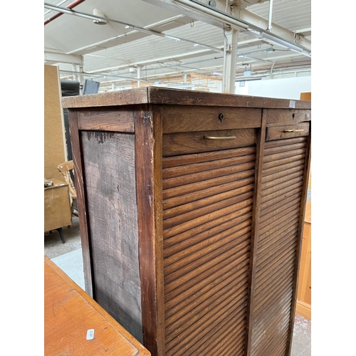 1031 - An early 20th century oak double tambour door cabinet - approx. 152cm high x 87cm wide x 37cm deep