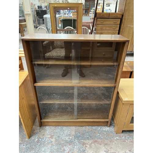 1034 - A Herbert Gibbs teak bookcase with four glass sliding doors - approx. 113cm high x 91cm wide x 24cm ... 