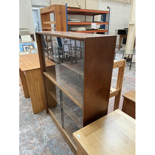 1034 - A Herbert Gibbs teak bookcase with four glass sliding doors - approx. 113cm high x 91cm wide x 24cm ... 