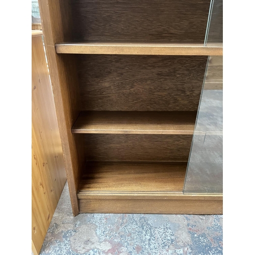 1034 - A Herbert Gibbs teak bookcase with four glass sliding doors - approx. 113cm high x 91cm wide x 24cm ... 