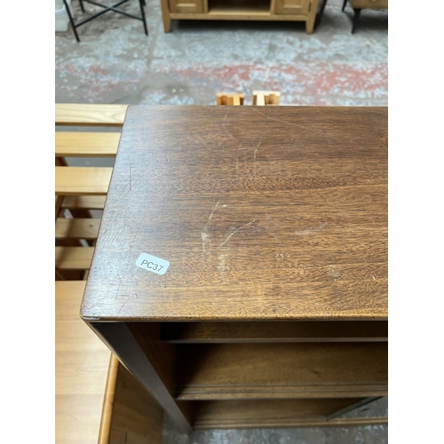 1034 - A Herbert Gibbs teak bookcase with four glass sliding doors - approx. 113cm high x 91cm wide x 24cm ... 