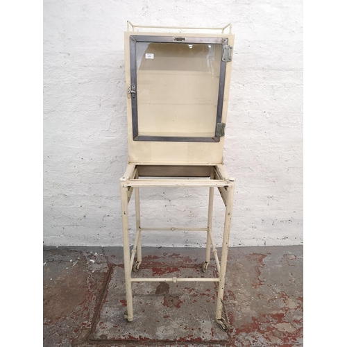 1041 - A mid 20th century The Holborn Surgical Instrument Co. Ltd London white painted medical cabinet on c... 