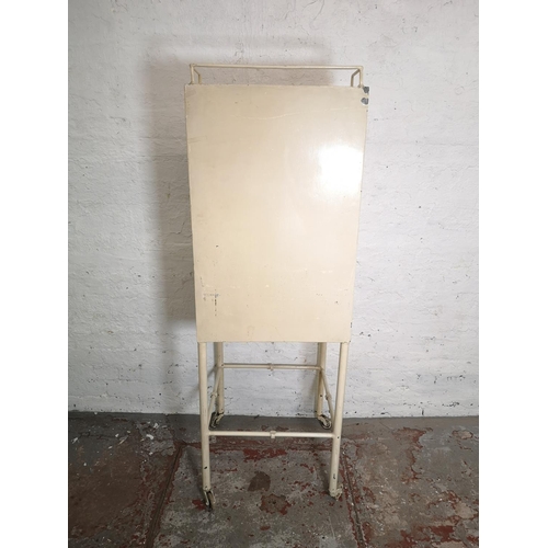 1041 - A mid 20th century The Holborn Surgical Instrument Co. Ltd London white painted medical cabinet on c... 