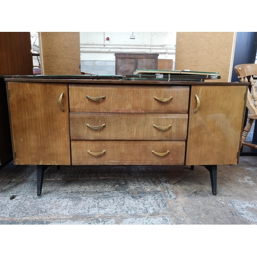 1052 - A mid 20th century walnut effect four piece bedroom suite comprising dressing table, double wardrobe... 