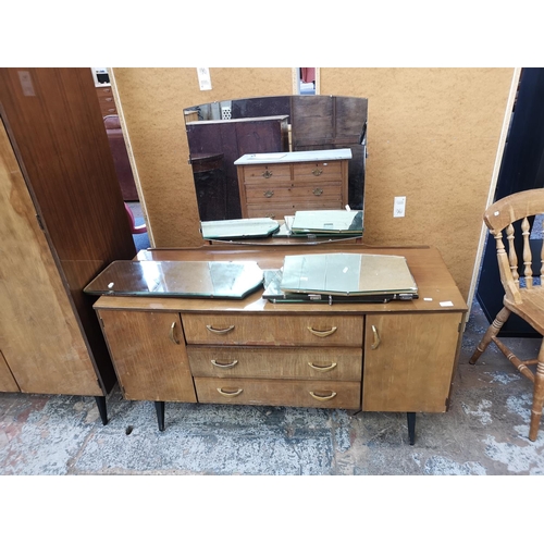 1052 - A mid 20th century walnut effect four piece bedroom suite comprising dressing table, double wardrobe... 