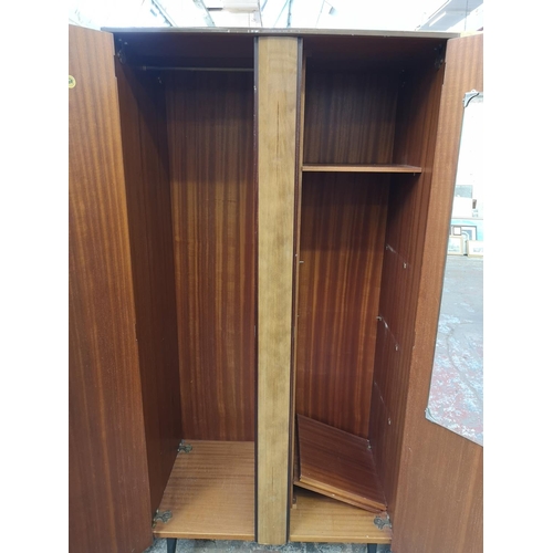 1052 - A mid 20th century walnut effect four piece bedroom suite comprising dressing table, double wardrobe... 